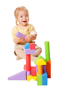 Baby girl building from toy blocks.